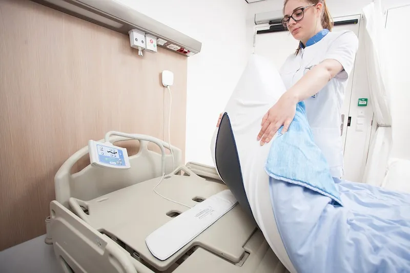 A nurse installing the sensor in a bed