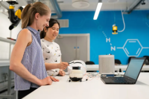 Two women programming a robot