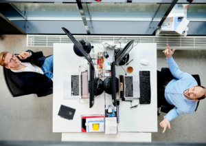 People at the office sitting in front of each other looking up to the camera above them